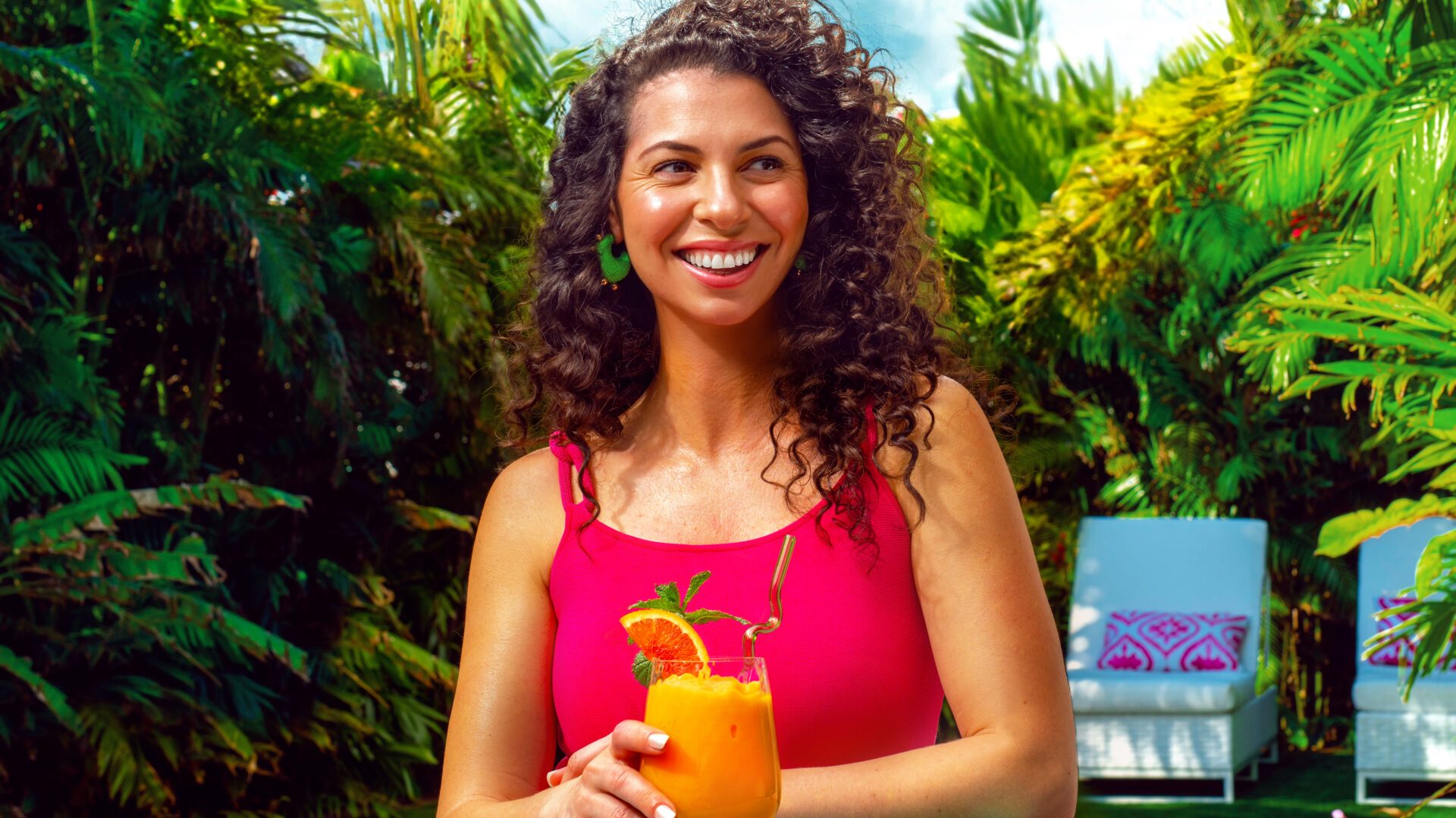 A smiling woman holding a glass of Peelz Cara Cara Berry Smoothie